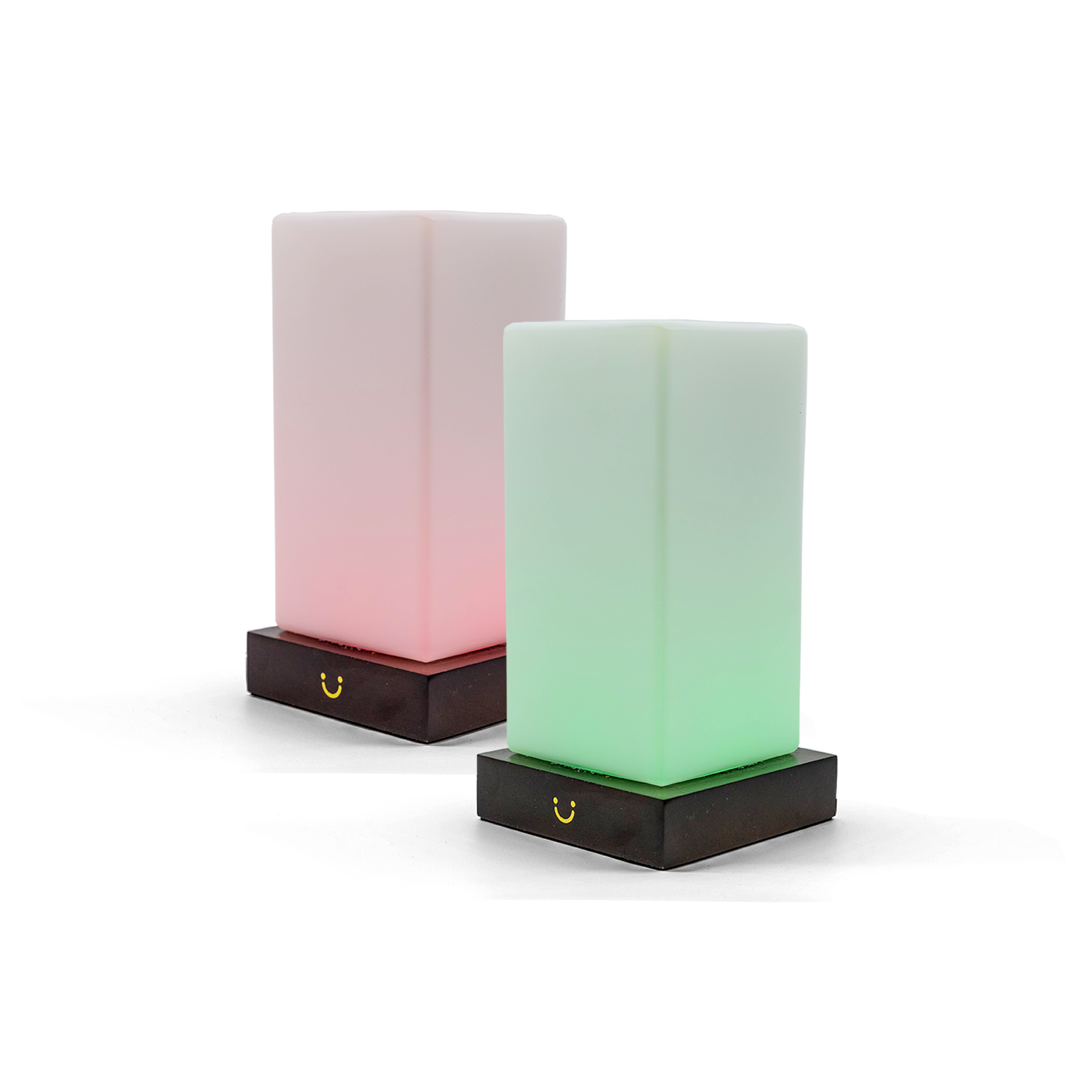 Two modern tower lamps glowing pink and green on black bases.